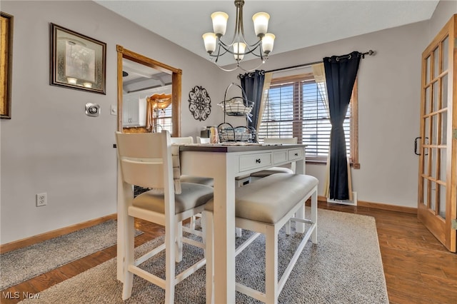 dining space featuring hardwood / wood-style flooring and a notable chandelier