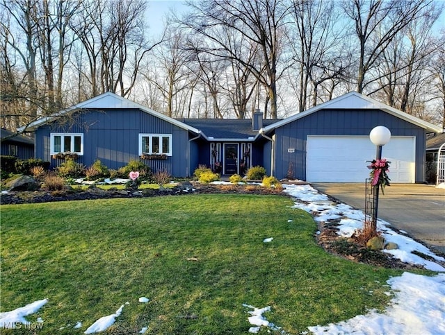 ranch-style house featuring a garage and a lawn