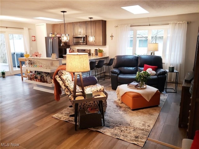 living room with dark hardwood / wood-style flooring and a skylight