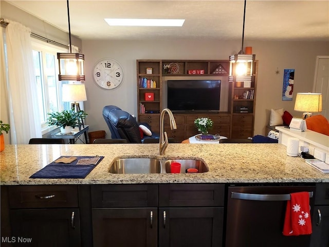 kitchen featuring sink, stainless steel dishwasher, light stone counters, and pendant lighting