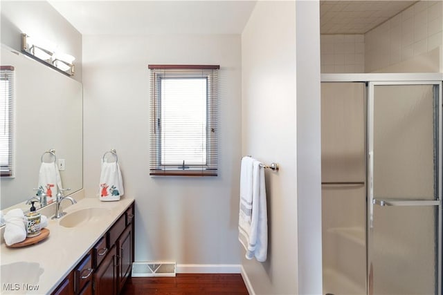 bathroom featuring an enclosed shower, vanity, and hardwood / wood-style flooring