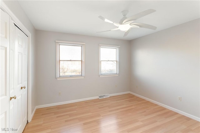 unfurnished bedroom featuring light hardwood / wood-style flooring, a closet, and ceiling fan