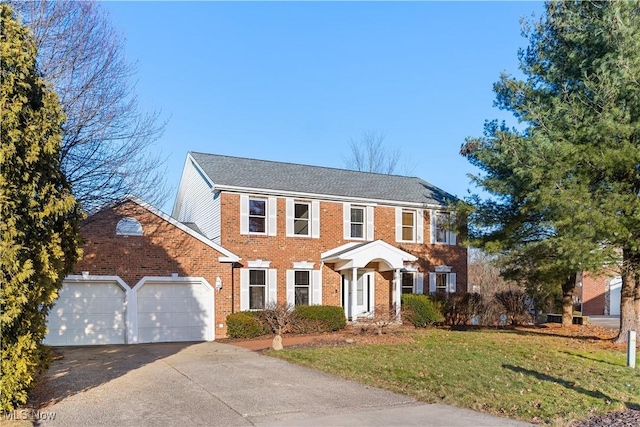 colonial home with a garage and a front lawn