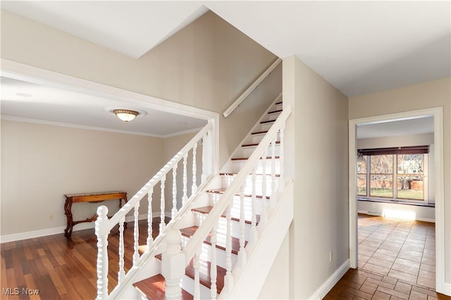 staircase featuring wood-type flooring and ornamental molding