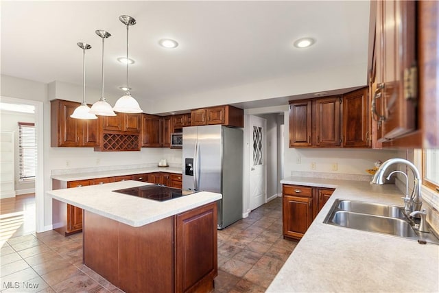 kitchen featuring stainless steel appliances, pendant lighting, a center island, and sink