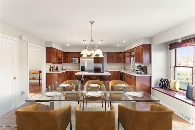 dining room with an inviting chandelier, light tile patterned flooring, and sink