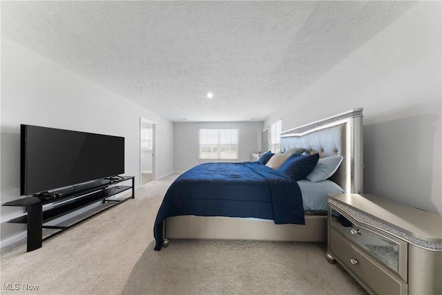 bedroom featuring light colored carpet and a textured ceiling