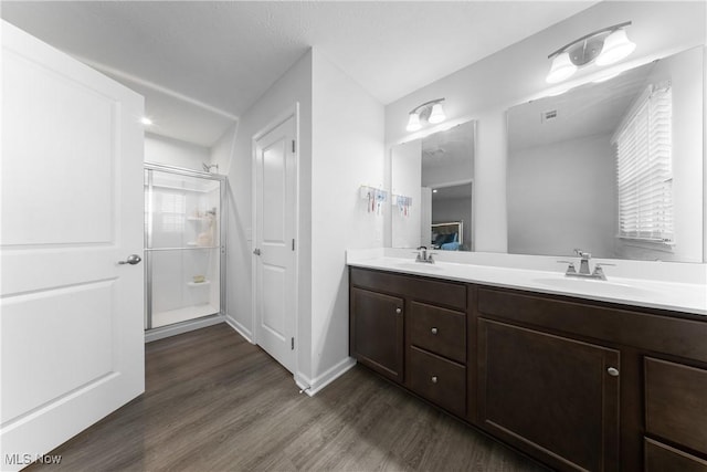 bathroom featuring vanity, hardwood / wood-style floors, and a shower with door