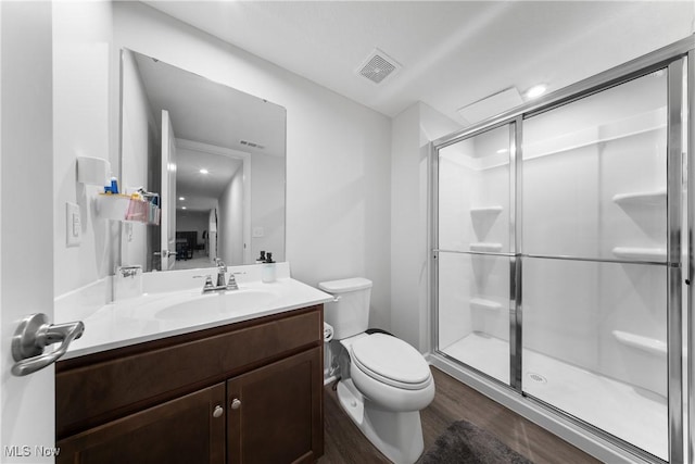 bathroom featuring walk in shower, vanity, toilet, and hardwood / wood-style flooring