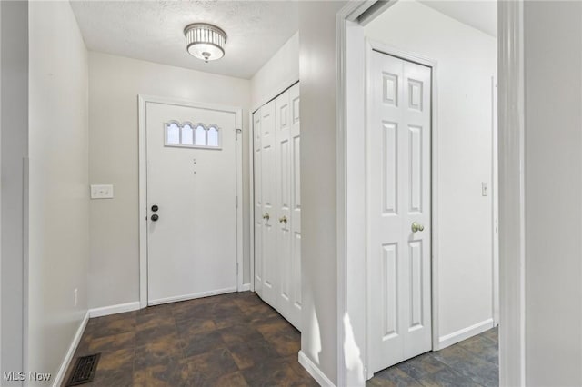 foyer entrance featuring a textured ceiling