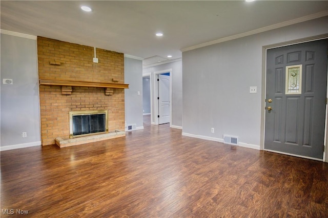 unfurnished living room featuring a brick fireplace, crown molding, and dark hardwood / wood-style floors