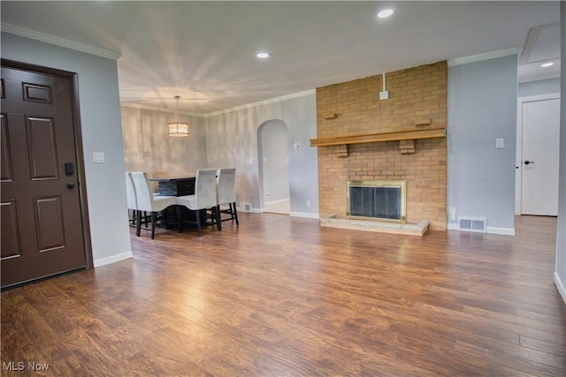 living room featuring a fireplace, ornamental molding, and dark hardwood / wood-style floors