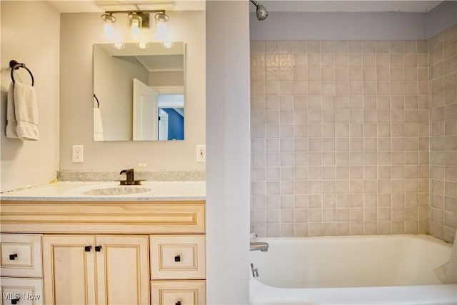 bathroom with tiled shower / bath combo and vanity