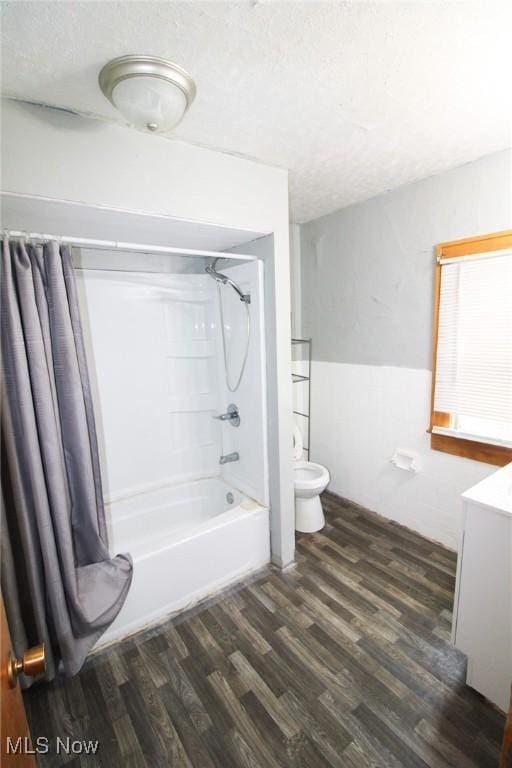 full bathroom with shower / tub combo with curtain, toilet, wood-type flooring, a textured ceiling, and vanity