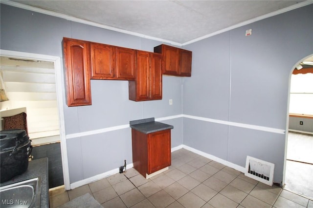 kitchen with ornamental molding and light tile patterned floors