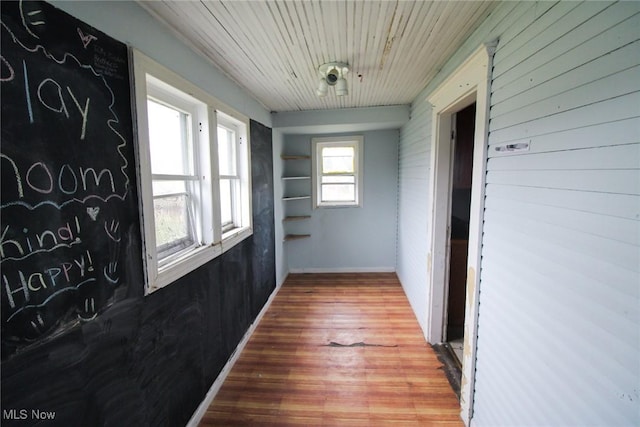 corridor featuring wood-type flooring and wood ceiling