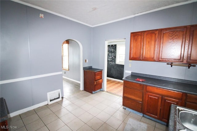 kitchen with ornamental molding and light tile patterned floors