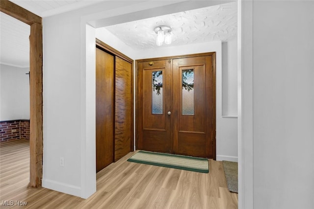 foyer featuring baseboards and wood finished floors
