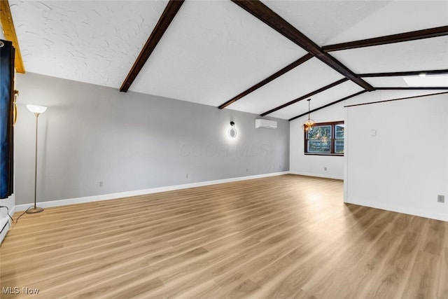 unfurnished living room featuring vaulted ceiling with beams, a wall mounted air conditioner, light wood finished floors, and baseboards