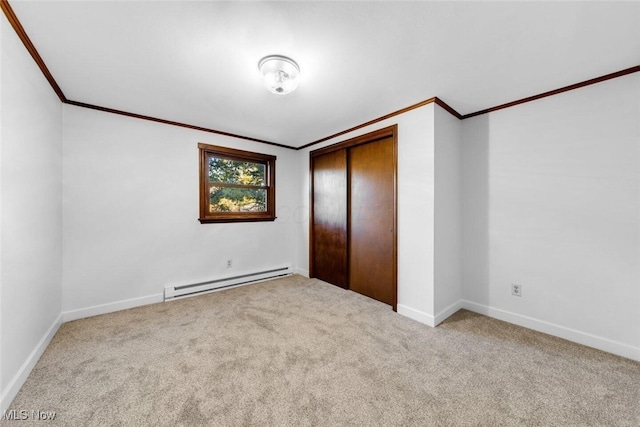 unfurnished bedroom with crown molding, baseboards, carpet floors, and baseboard heating