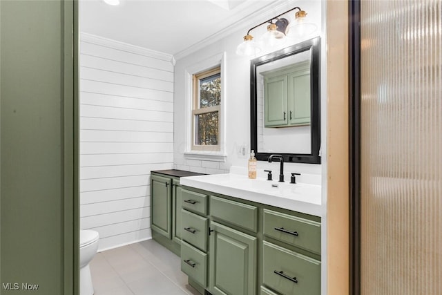 bathroom featuring vanity, ornamental molding, toilet, wooden walls, and tile patterned floors
