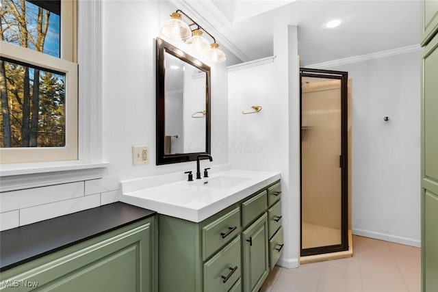 full bathroom featuring vanity, ornamental molding, tile patterned flooring, baseboards, and a shower stall