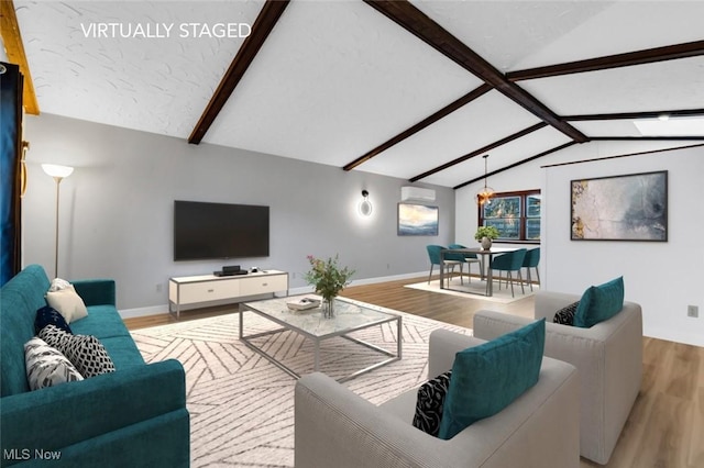 living area featuring vaulted ceiling with beams, baseboards, a wall mounted AC, and wood finished floors