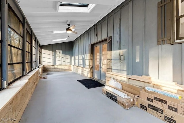 interior space with concrete flooring, wooden walls, and a skylight
