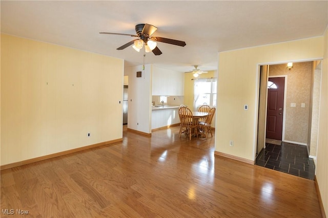 unfurnished living room featuring hardwood / wood-style flooring and ceiling fan