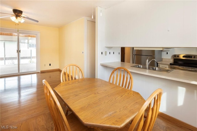 dining area with sink, light hardwood / wood-style flooring, and ceiling fan