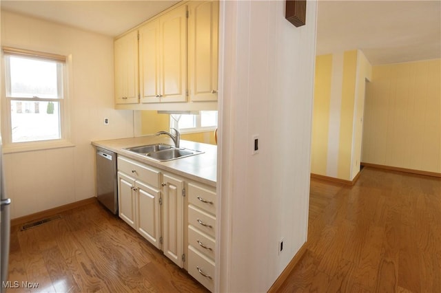 kitchen featuring sink, stainless steel dishwasher, and light wood-type flooring