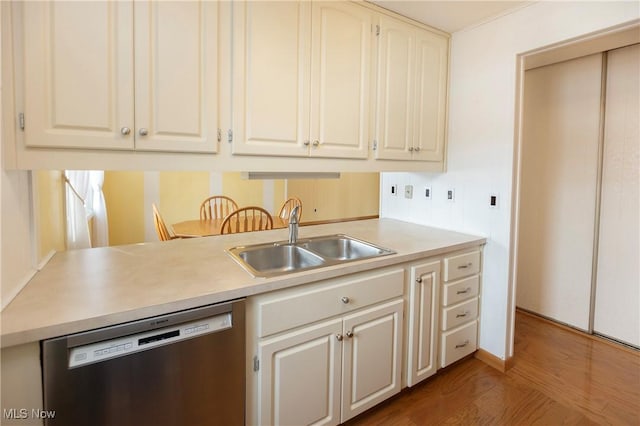 kitchen with hardwood / wood-style floors, sink, and stainless steel dishwasher