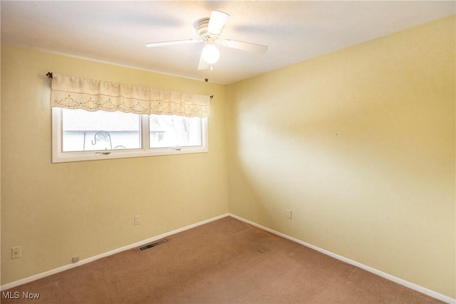 carpeted spare room featuring ceiling fan