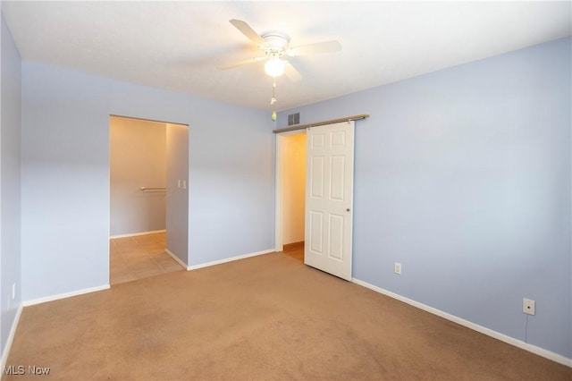 unfurnished bedroom featuring ceiling fan and light colored carpet