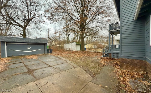 exterior space with a garage, a balcony, and an outdoor structure