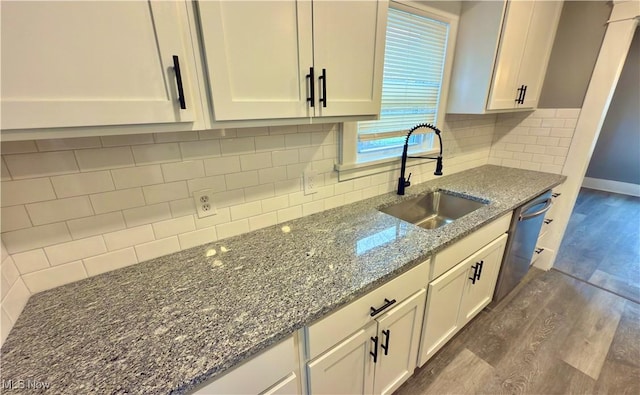 kitchen with white cabinetry, dark stone countertops, sink, and dark wood-type flooring