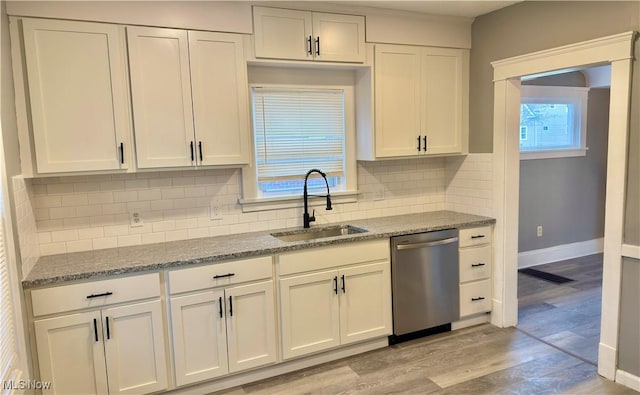 kitchen with sink, white cabinetry, stone countertops, stainless steel dishwasher, and light hardwood / wood-style floors