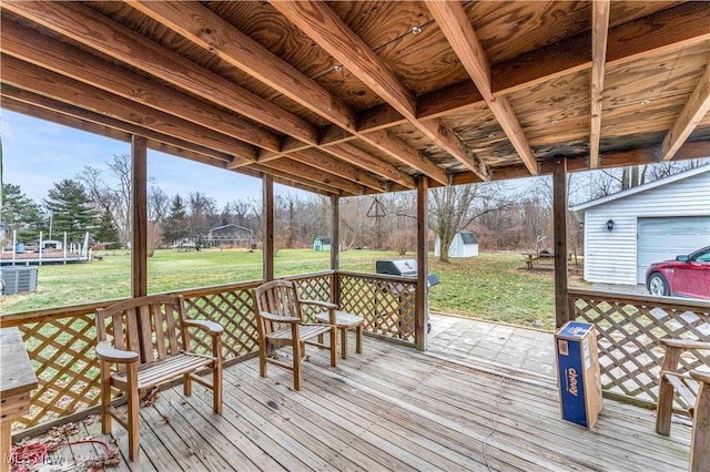 wooden deck with area for grilling, a yard, an outdoor structure, and central air condition unit