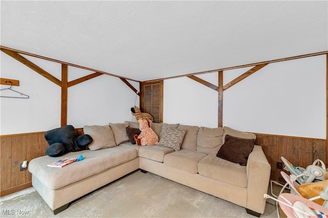 living room featuring vaulted ceiling and wood walls