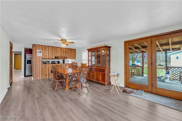 dining room with ceiling fan, light hardwood / wood-style floors, and a textured ceiling