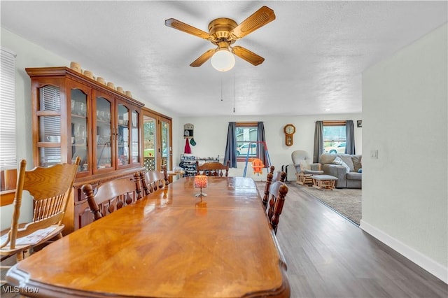 dining area with wood-type flooring, a textured ceiling, and ceiling fan