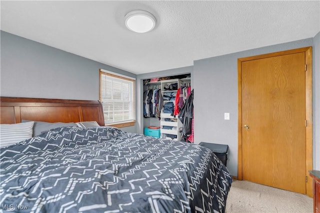 carpeted bedroom featuring a textured ceiling and a closet