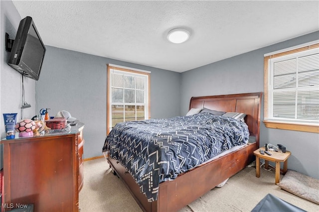 bedroom featuring light carpet and a textured ceiling