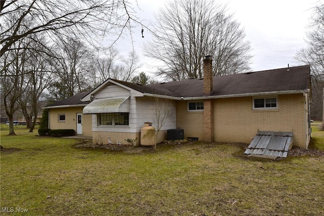 back of property featuring a yard and central AC unit