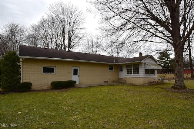 rear view of property with a yard