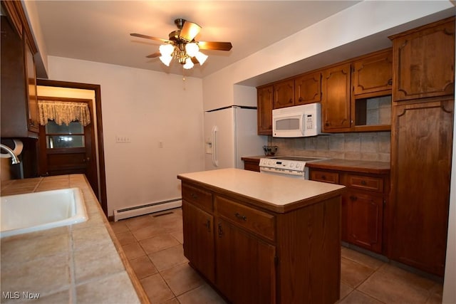 kitchen with sink, white appliances, a center island, tasteful backsplash, and a baseboard radiator