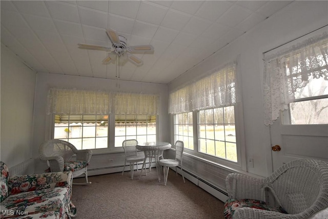 sunroom with plenty of natural light, a baseboard heating unit, and ceiling fan