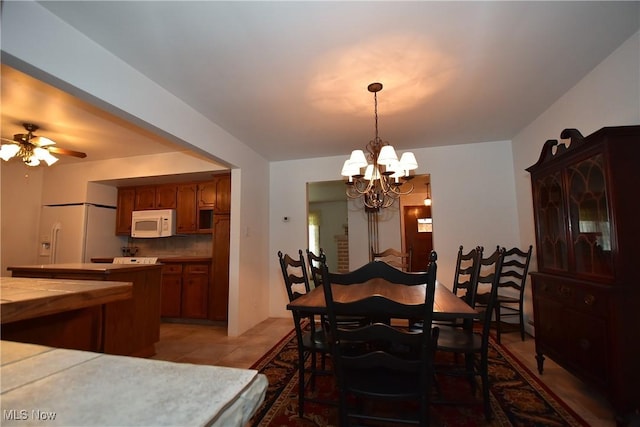 dining area featuring ceiling fan with notable chandelier and light tile patterned floors