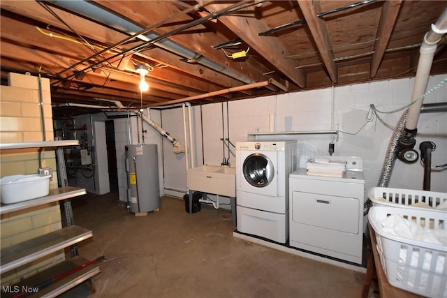 basement featuring electric water heater, sink, and washing machine and clothes dryer