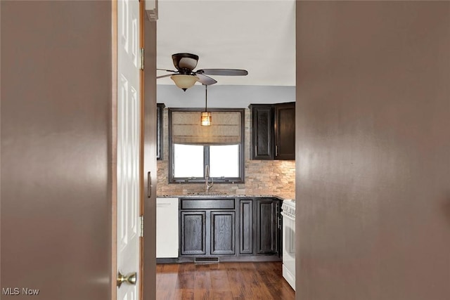 kitchen with sink, dark hardwood / wood-style floors, white appliances, light stone countertops, and decorative backsplash